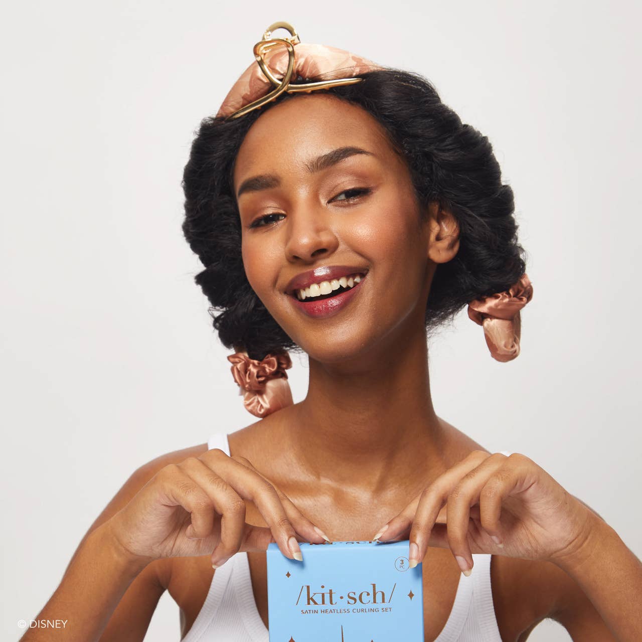 Blyskt Woman with styled hair holding a 'kit-sch' product box against a white background