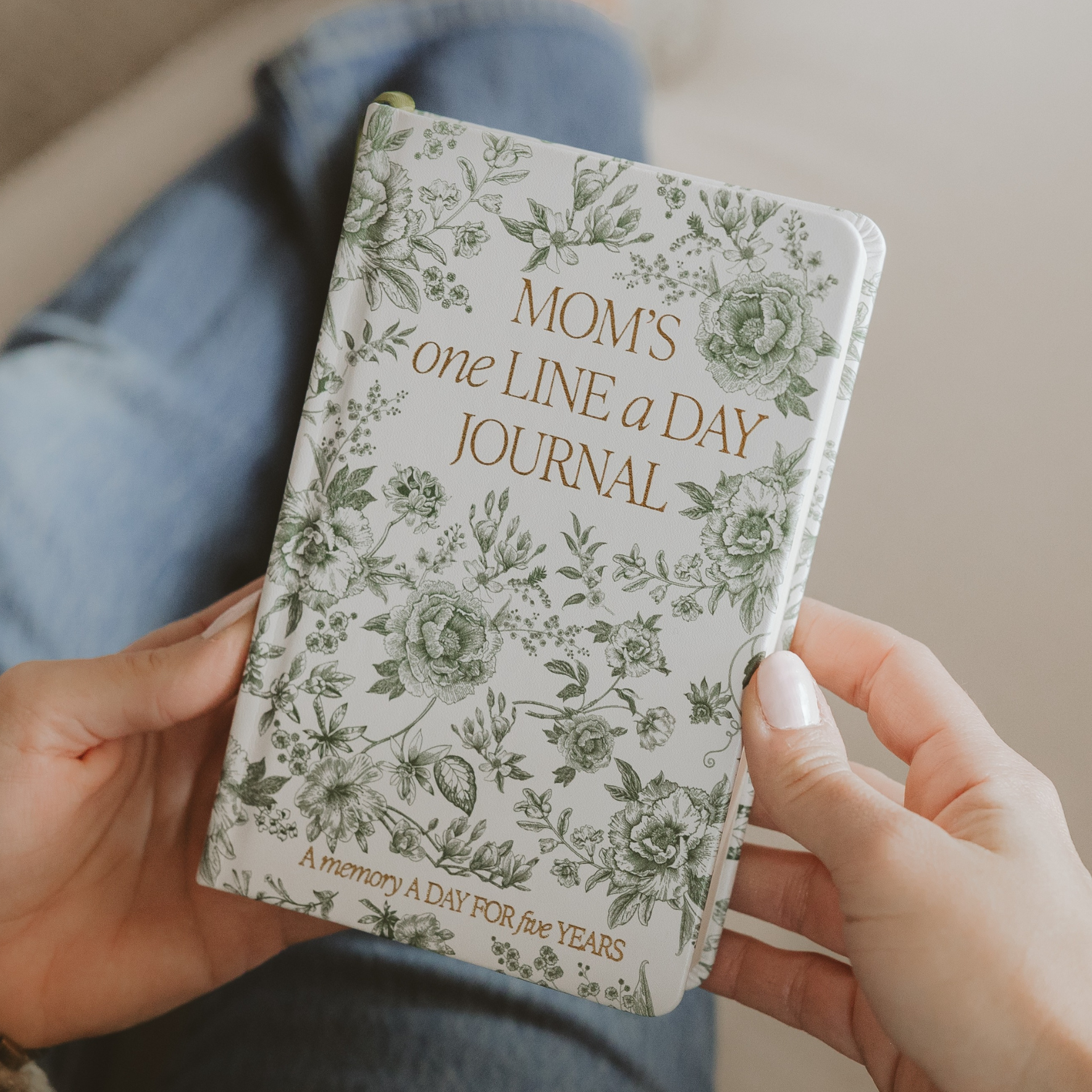 Blyskt Floral-patterned journal titled 'Mom's One Line a Day Journal' held by hands.