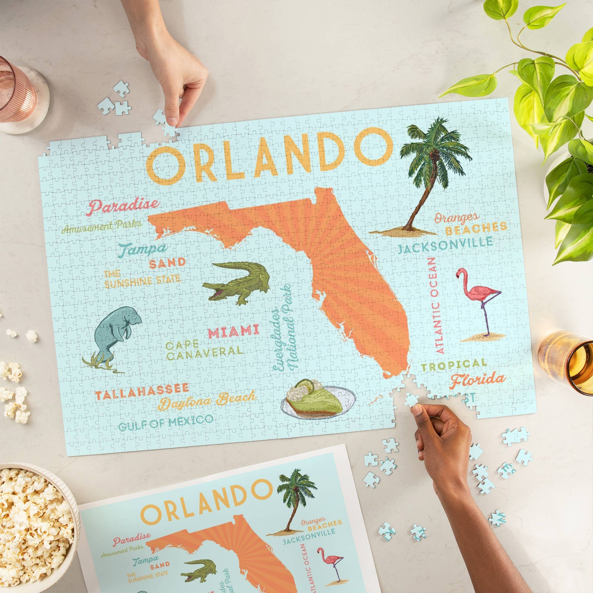 Blyskt Orlando-themed puzzle with decorative elements on a table with popcorn and a plant.