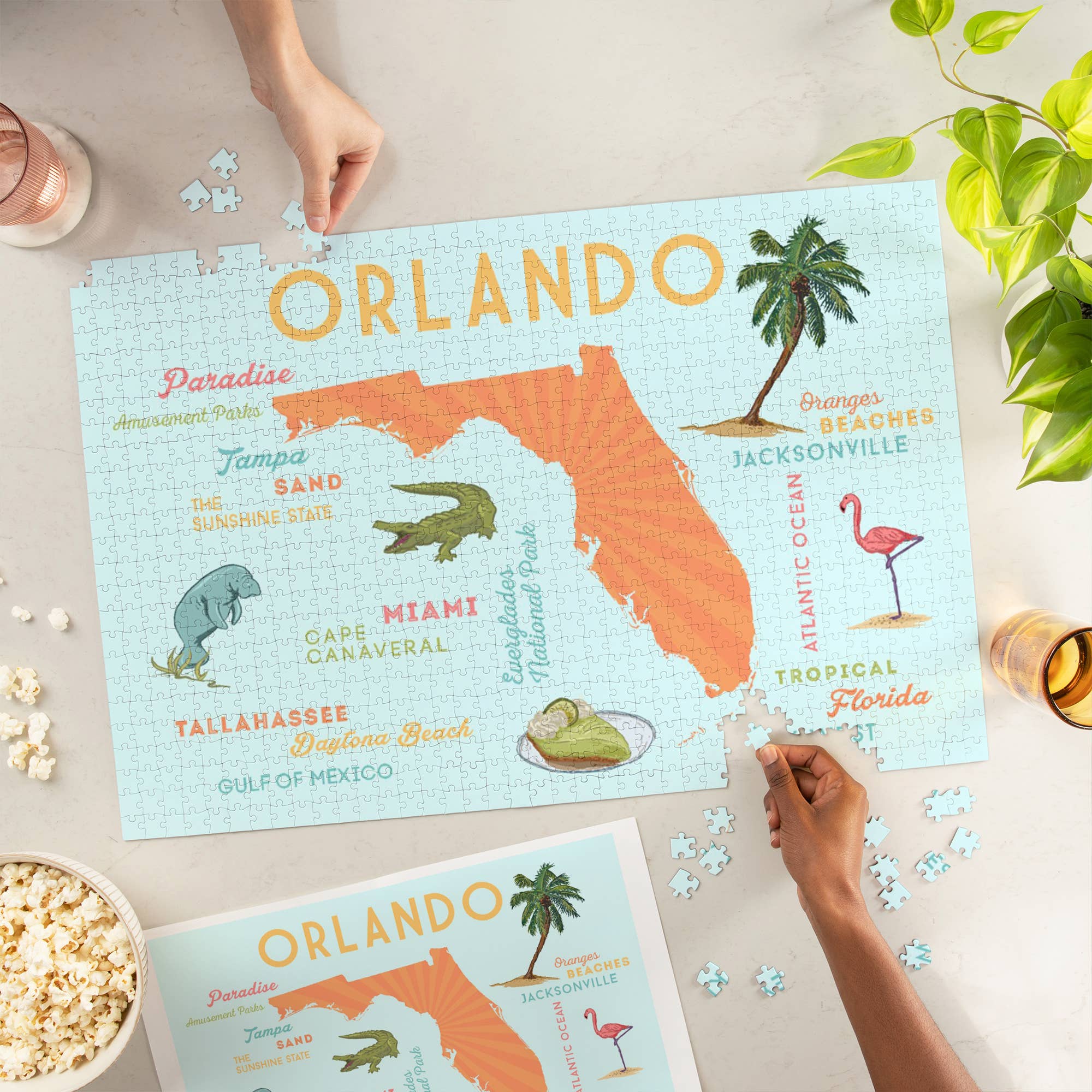Blyskt Orlando-themed puzzle with decorative elements on a table with popcorn and a plant.