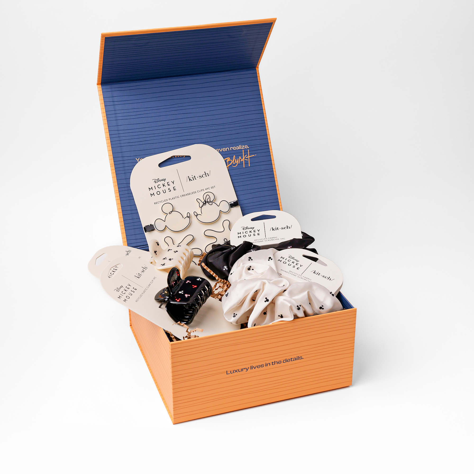 Open box containing Disney Mickey Mouse themed items on a white background