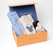 Gift box with stationery items and a black item on a white background