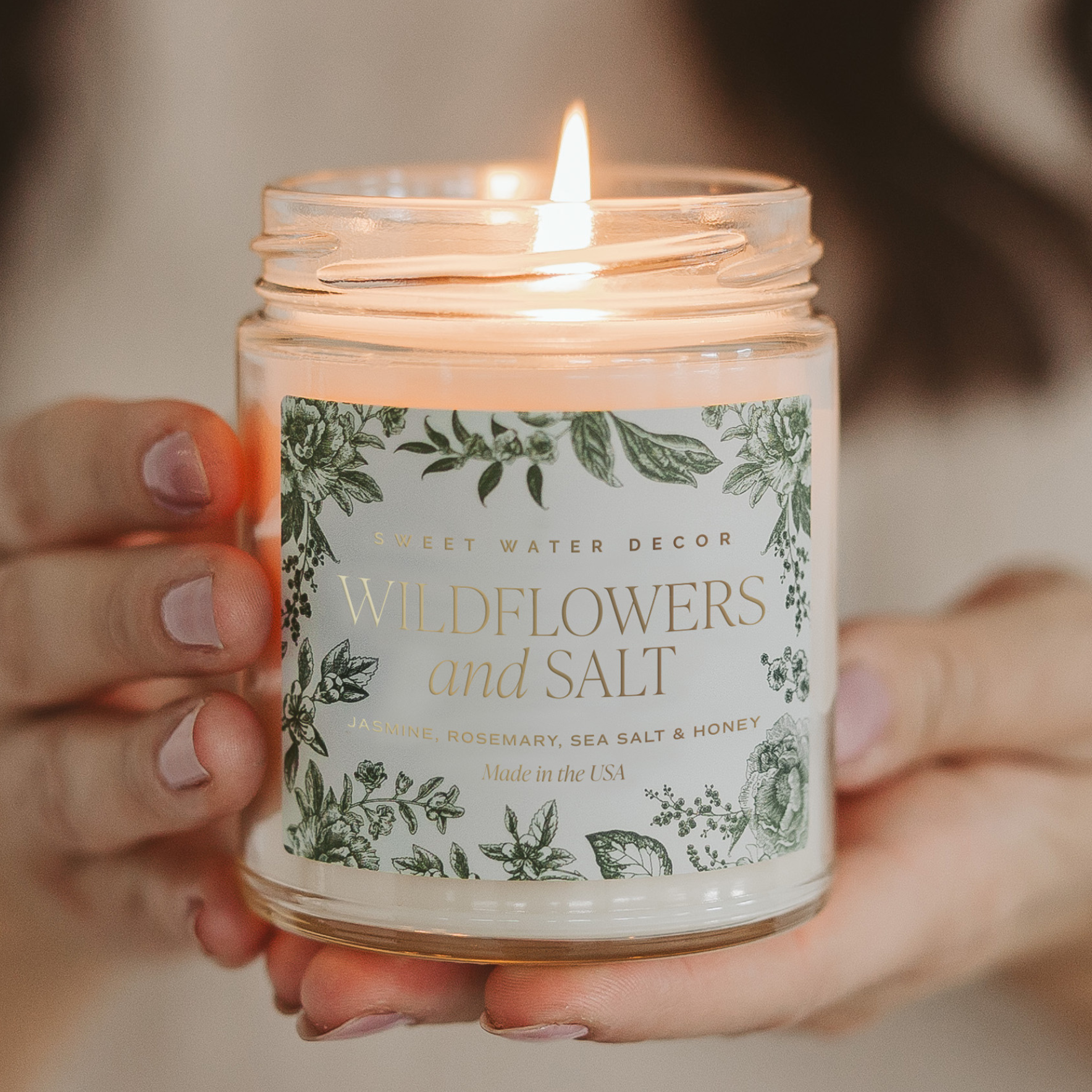 Blyskt Candle labeled 'Wildflowers and Salt' held by a person with a blurred background