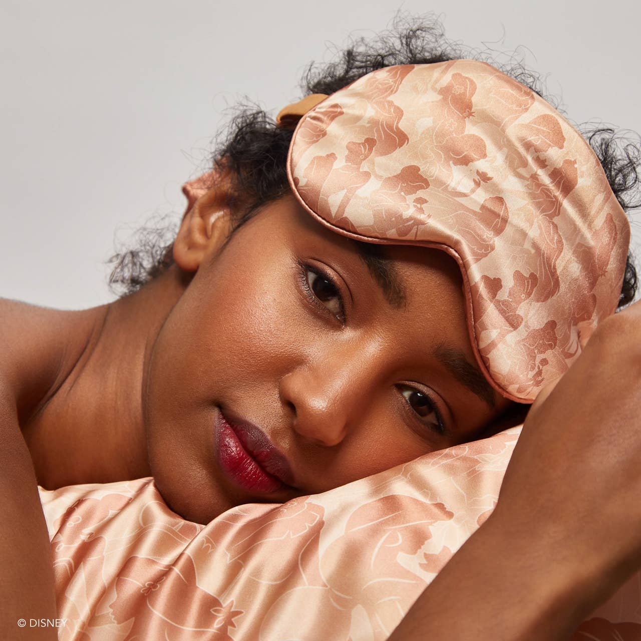 Blyskt Woman wearing a pink satin headband with floral pattern on a neutral background